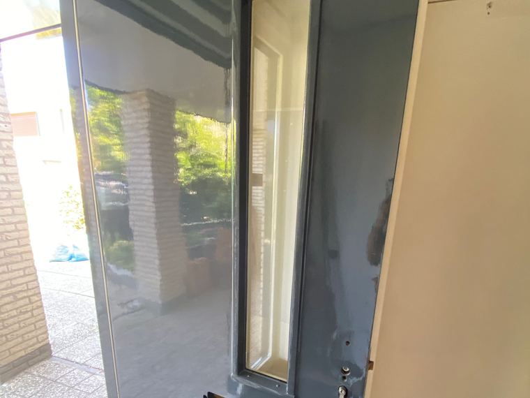 Opnieuw gelakte voordeur in grijsblauw, strak afgewerkt tot in de sponningen